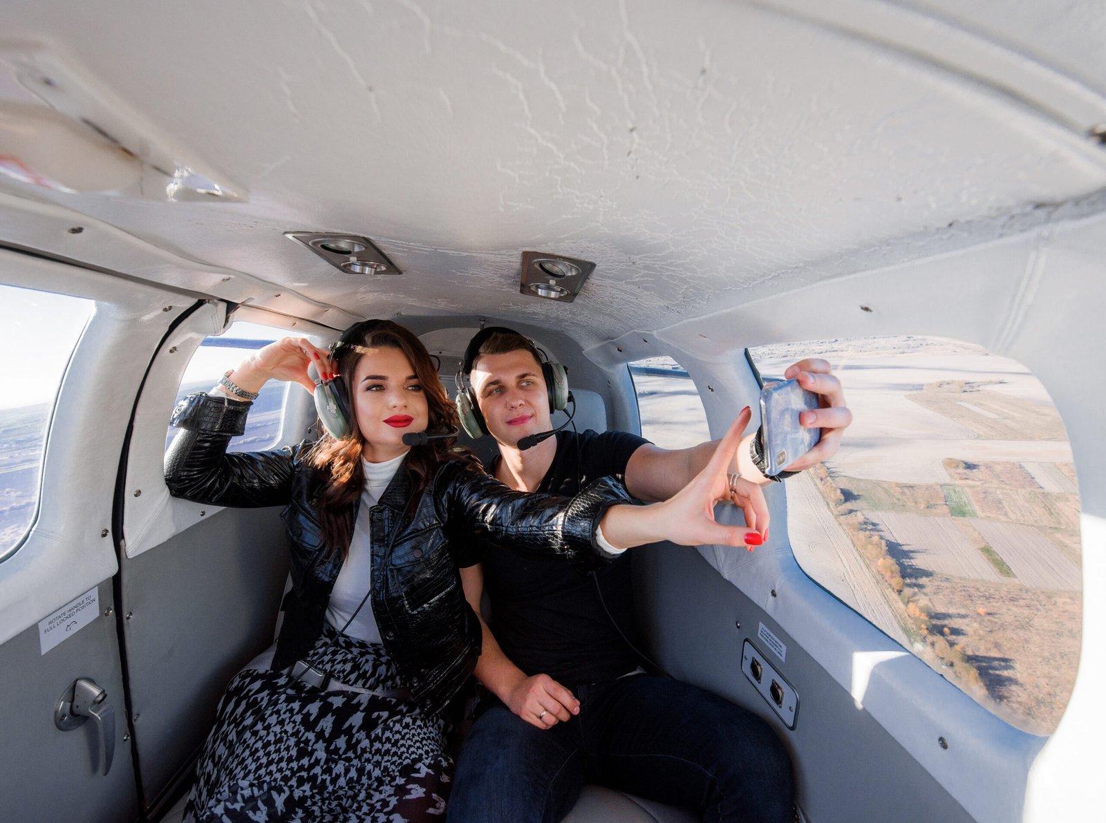 Beautiful couple is making selfie inside of helicopter with brea