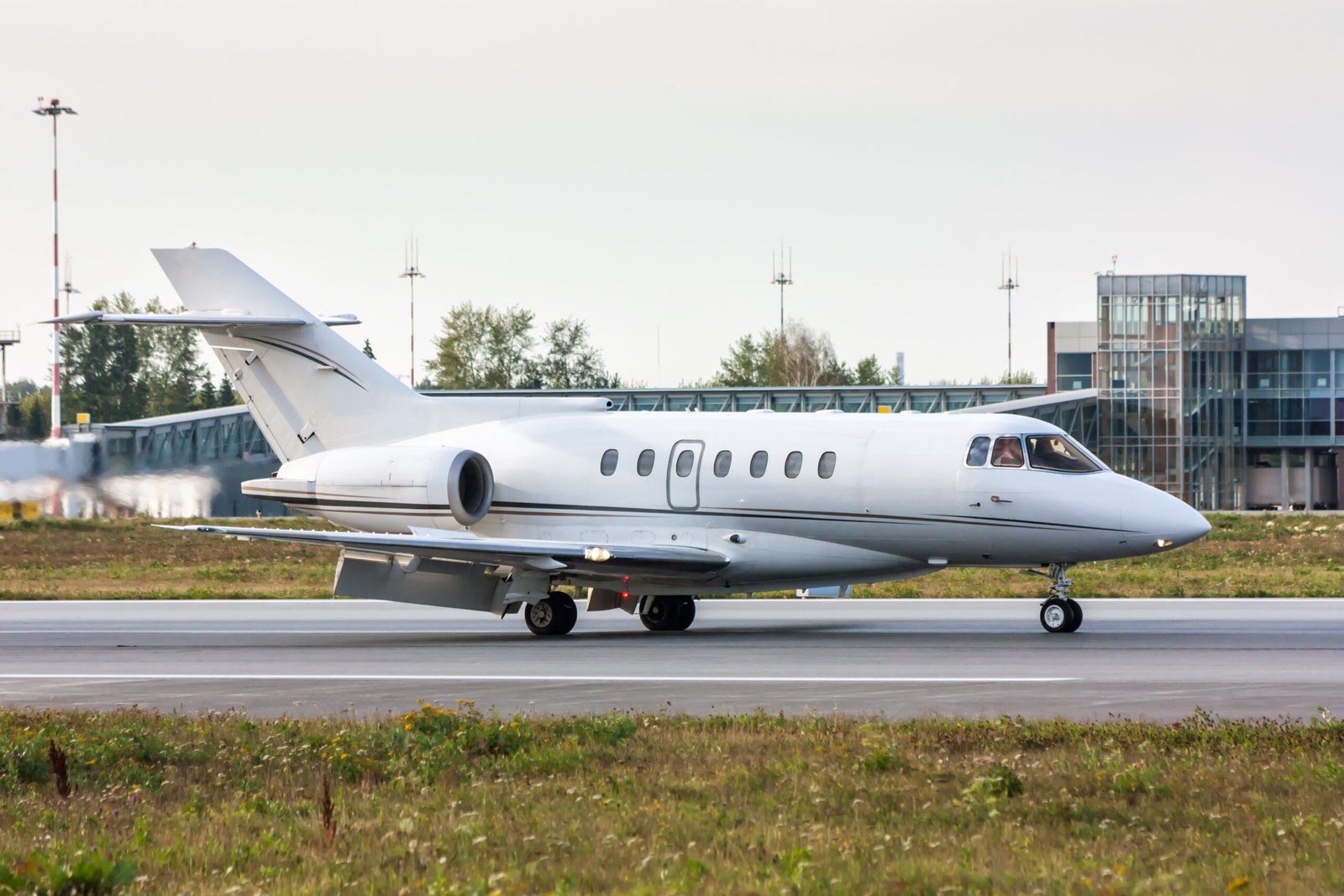 Business Jet on the runway in front of the airport terminal